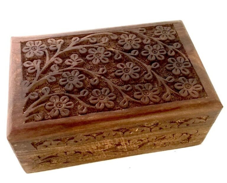 Wooden box with carved floral design on the lid and sides